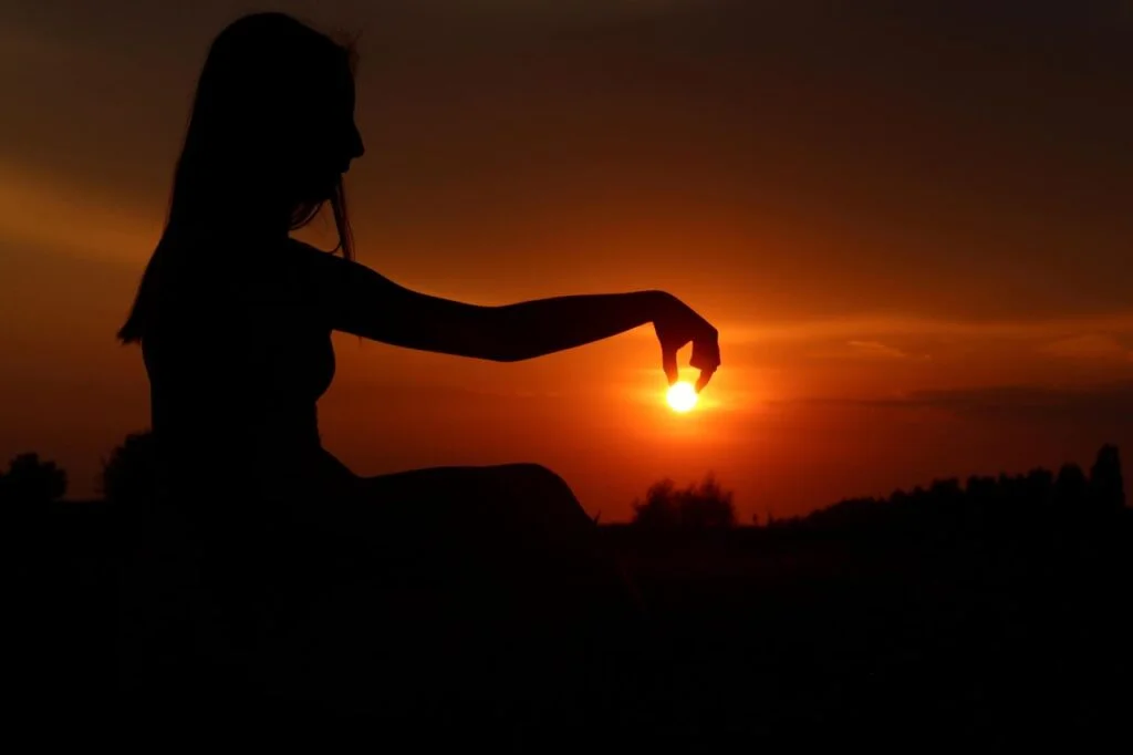 woman trying to cover sun with her fingers